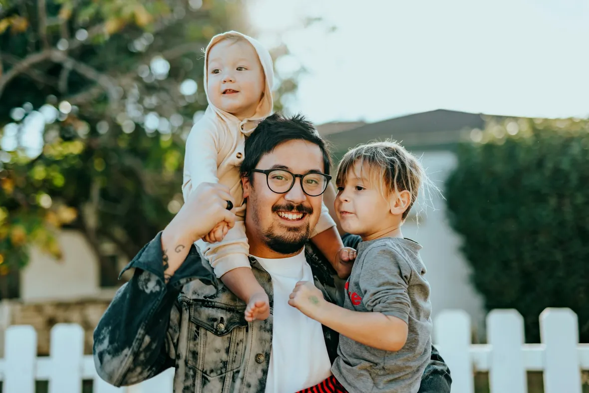 A father outside with his two young children